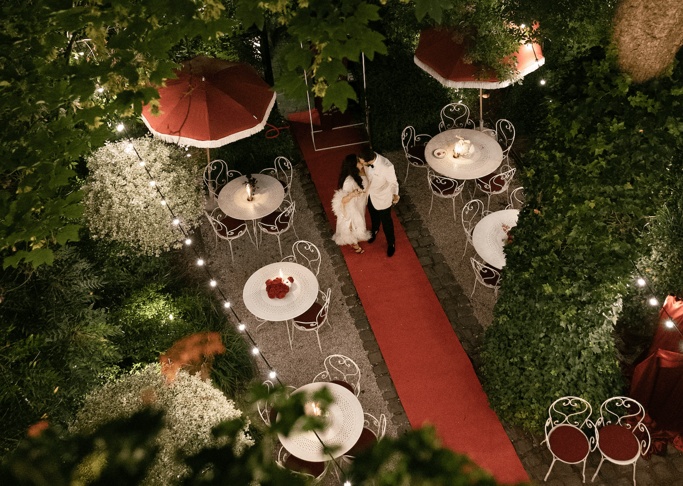 Serveurs en uniformes roses alignés devant l’entrée fleurie de l’Hôtel Particulier Montmartre, lors d’un événement.